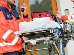 Trasferimento in autoambulanza da ospedale a ospedale, due paramedici trasportano una barella